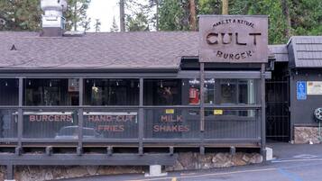 Ein rustikales Restaurant mit einem Schild, auf dem 'MAKE IT A RITUAL CULT BURGER' steht.