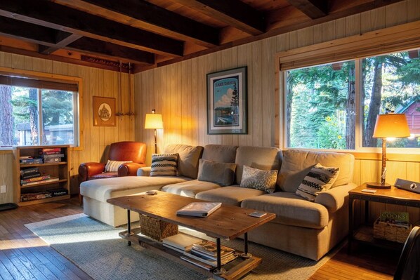 A cozy living room with a sofa, a coffee table, and a bookshelf.