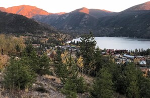 Uma cidade com edifícios perto de um lago, rodeada por montanhas.
