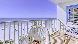 A balcony with a view of the beach and ocean.
