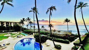 Ein Resort mit Swimmingpool, Liegestühlen und Palmen.