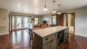 A spacious kitchen with a large island, wooden cabinets, and pendant lighting. -  Peaceful and luxurious living with spectacular views  (Spruce Pine)