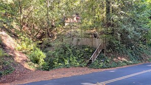 Une zone boisée avec un pont en bois et un bâtiment en arrière-plan.