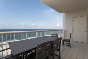 Ein Balkon mit Blick aufs Meer, ein Tisch und zwei Stühle.