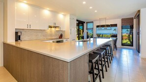 A modern kitchen with a large island, built-in appliances, and a view of the ocean. - Designer - Best View!Ground Flr 2 Bdm/2Bth 39c! Remaining Fall$400 (Kihei)