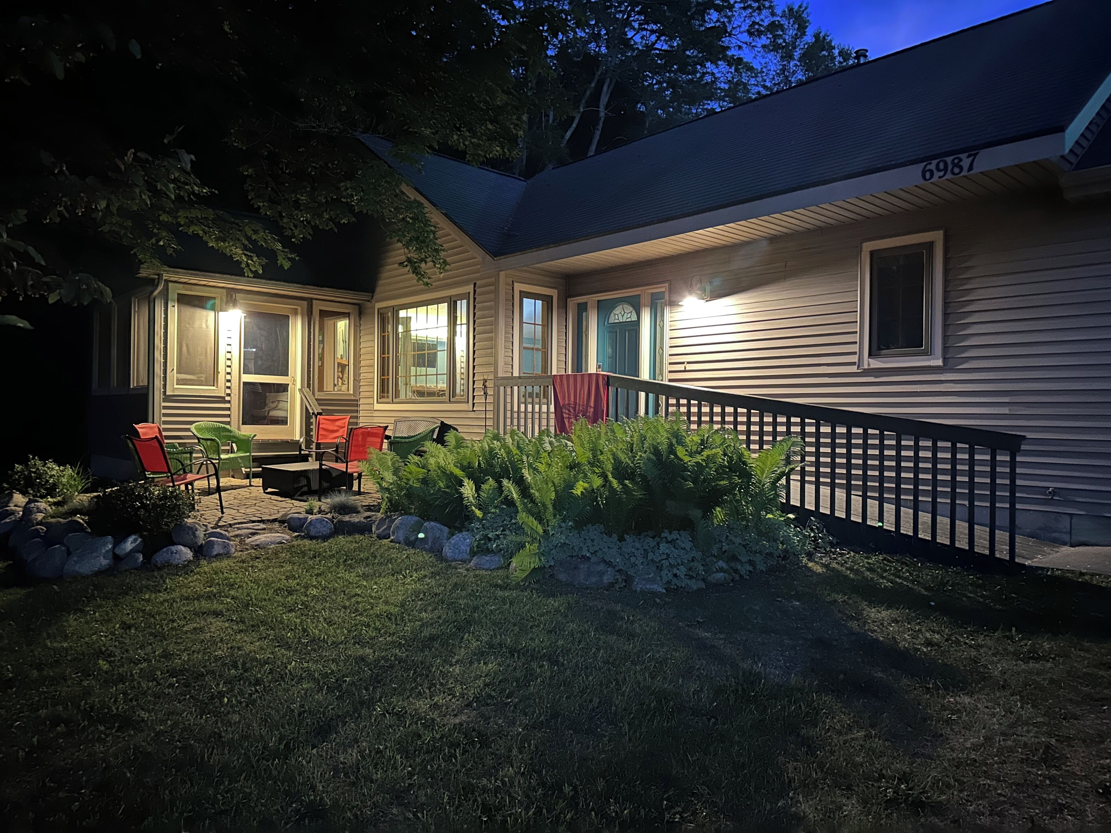 A house with a covered porch, outdoor seating, and a well-maintained garden.
