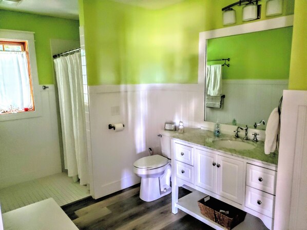 Une salle de bain avec des toilettes, un lavabo et un miroir.