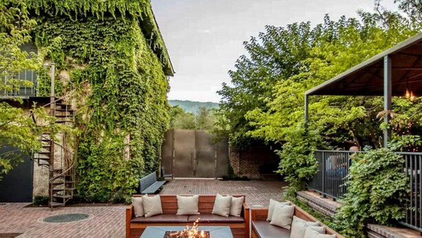 A patio with a fire pit, seating area, and a wall covered in ivy. - Walk to Restaurants, Wineries and More (Saint Helena)