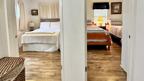 Una habitación con cama, una silla, una lámpara y un ventilador de techo.
