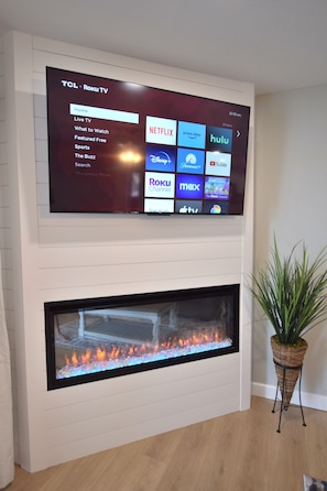 A TCL Roku TV mounted on a wall above a fireplace. - A COZY GETAWAY!Spectacular Main Channel Wtrfrt Condo Walkin Level 2BR-Unit 10210 (Osage Beach)