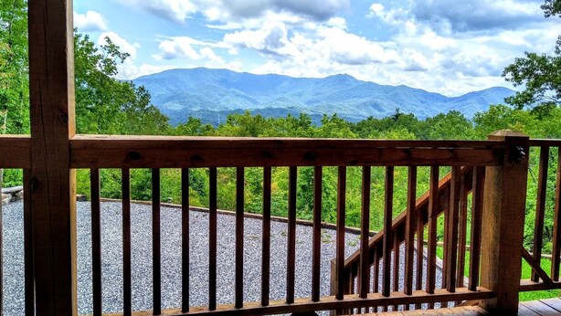 A wooden deck with a view of mountains and greenery. - Brooke's Place Deep Creek Area in Bryson City- Luxury Cabin (Bryson City)