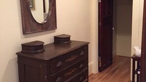 A room with a wooden dresser, a large mirror, and a door leading to another room. - Location, Beauty & Free Parking In Downtown Capitol Hill! (Washington)