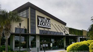 Een Whole Foods winkel met een modern ontwerp, grote ramen en een opvallend bord.