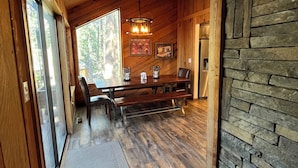 Un interior de madera con una mesa de comedor, sillas y una pared de piedra.