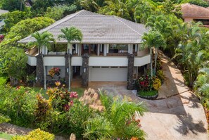 A two-story house with a tiled roof, surrounded by lush tropical vegetation and a well-maintained garden. - Plumeria House, Poipu Beach, Koloa Home with a View  (Koloa)