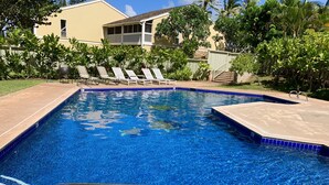 A swimming pool with a tiled edge, a metal ladder, and lounge chairs. -  Closest to Hotel and Beach, Split Air Conditioners (Kahuku)