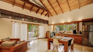 Une cuisine spacieuse dotée de meubles en bois, d’un réfrigérateur en acier inoxydable et d’un coin repas avec une table et des chaises en bois.