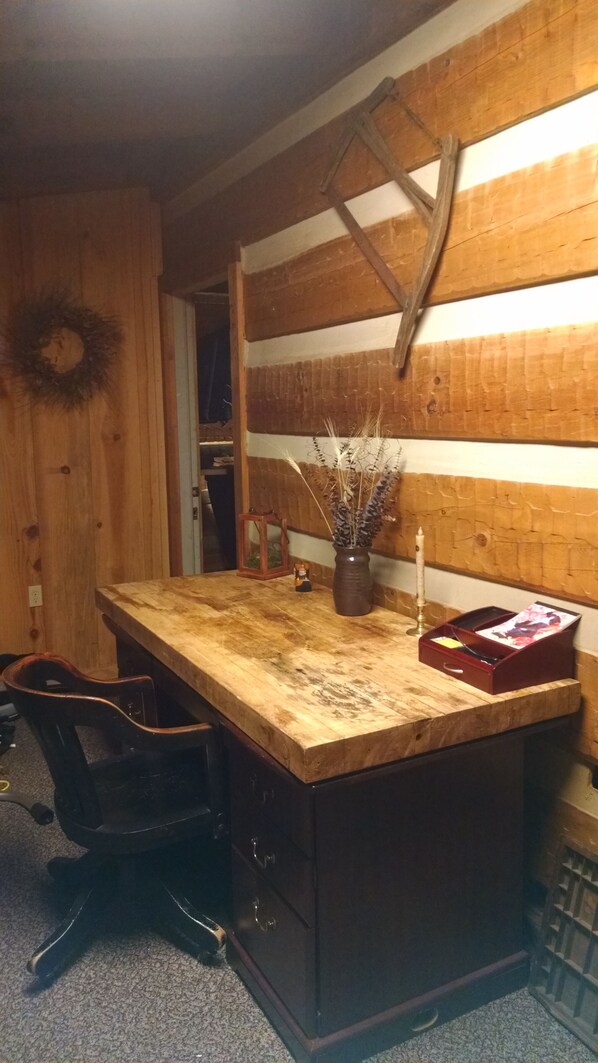 A kitchen with a wooden island, a sink, and a vase with dried plants. - Fully furnished log cabin, family and pet friendly. (Apex)