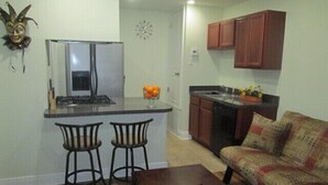 A compact living space with a kitchenette, a sofa, and a coffee table. - Mardi Gras Cottage, 4 km to French Quarter (ARABI)
