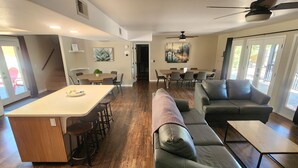 A spacious living area with a central island, a sofa, and a dining table. - Papago Pines - 5 bedrooms, EACH WITH ATTACHED EN SUITE BATHROOM & Smart TV (Munds Park)