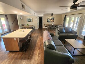 Amplia sala de estar con una isla central, un sofá y una mesa de comedor.