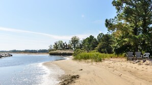 A beach with clear water, sandy shore, and trees. There are two white chairs near the water. - 240' Private Beachfront @Kent Island Love Point - Great for Families (stevensville)
