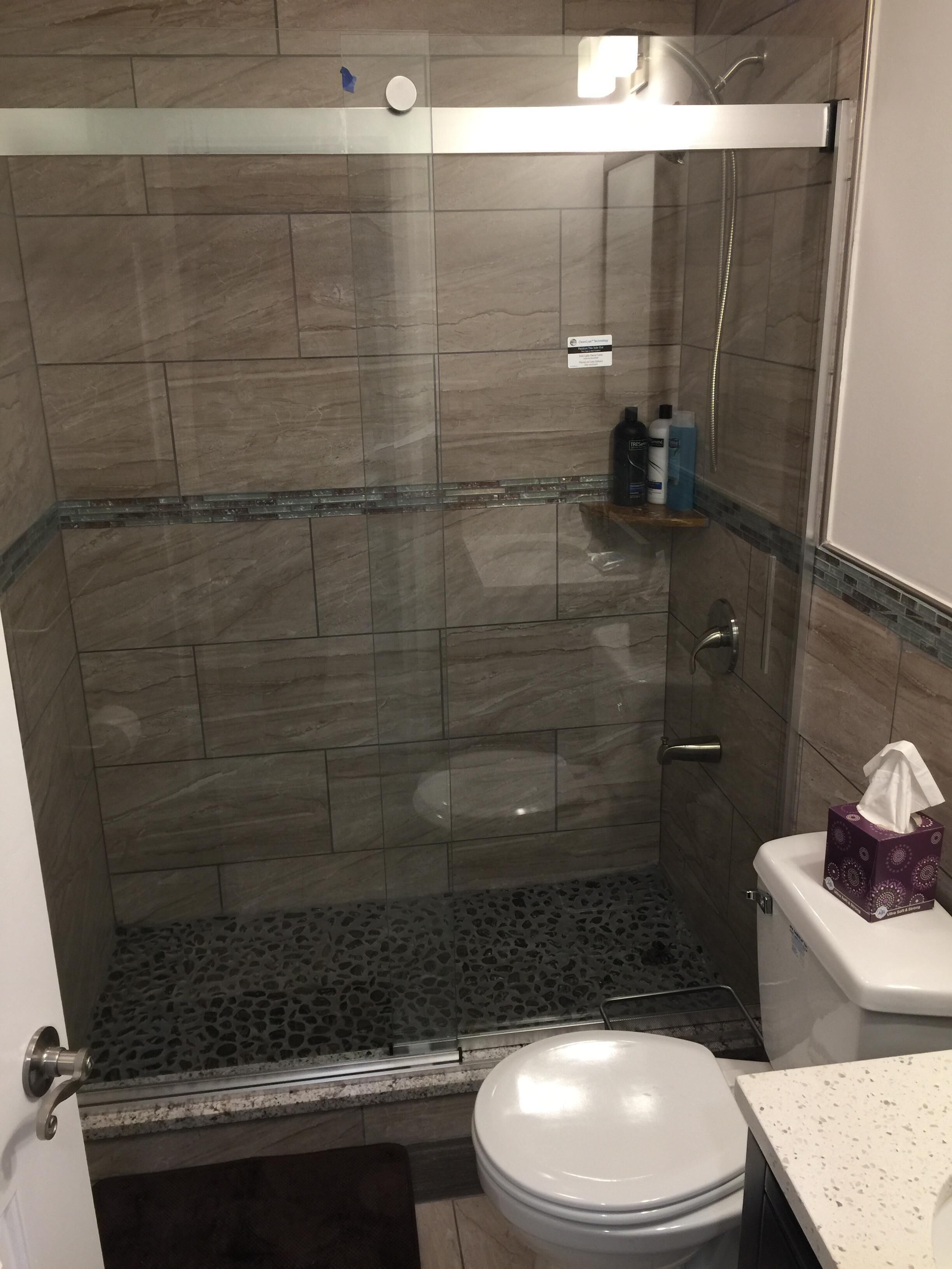 Ein Badezimmer mit Duschkabine, Toilette und Waschbecken mit Marmorplatte.