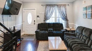A living room with a flat-screen TV, a recliner, a sofa, and a coffee table. - Spacious 4BD/3Bath, HUGE Rooftop deck and patio. Amazing Views! (Philadelphia)