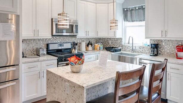 A modern kitchen with white cabinets, a central island, stainless steel appliances, and pendant lighting. - Spacious 4BD/3Bath, HUGE Rooftop deck and patio. Amazing Views! (Philadelphia)
