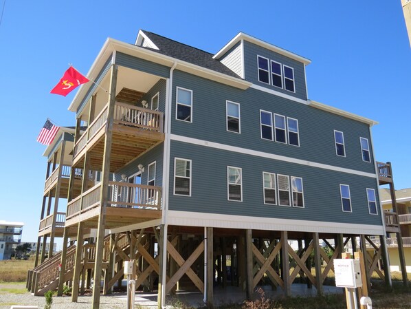 A multi-story building with a wooden deck, balconies, and a flag.