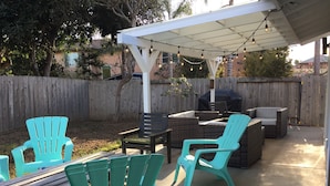 A patio with outdoor furniture, a pergola, and string lights.
