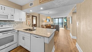 A modern kitchen with white cabinetry, a granite countertop, and a built-in dishwasher. - Oceanfront Condo, Gorgeous, Clean & Remodeled located at Sands Beach Club #325 (Myrtle Beach)