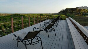 Una terraza con filas de sillas mirando un paisaje natural.