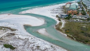 An aerial view of a coastal area with a beach, a curving waterway, and buildings with a light-colored facade. - Eastern Lake Lakefront! Easy access to the Gulf! Pirate Ship & Treehouse! (Santa Rosa Beach)