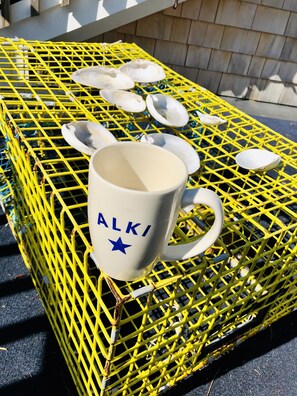 Una jaula de metal amarillo con una taza blanca etiquetada 