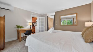 Een hotelkamer met een bed, bureau, stoel en een raam met uitzicht.