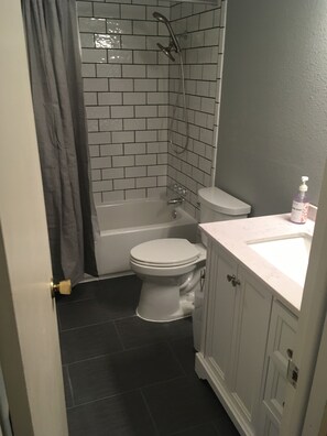Une salle de bain équipée de toilettes, d’une baignoire et d’une douche.