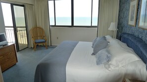 Enjoy a restful stay in this inviting room with a large bed, sea views, and a comfortable chair.