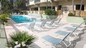 Un espace piscine doté de chaises longues et d’une piscine à eau claire.