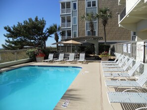 Relax by the pool surrounded by comfortable lounge chairs and lush greenery.