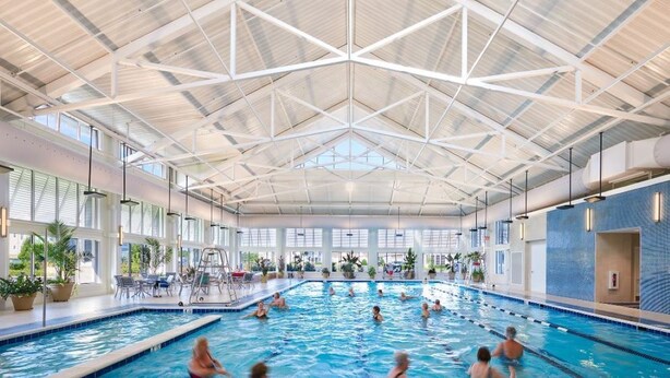 An indoor swimming pool with a high ceiling and large windows. - Upscale Beach & Golf Getaway At Bayside Resort (Selbyville)