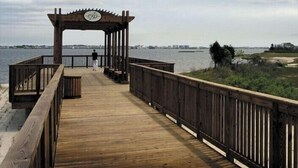 A wooden pier with a gazebo at the end, leading to a body of water. - Upscale Beach & Golf Getaway At Bayside Resort (Selbyville)
