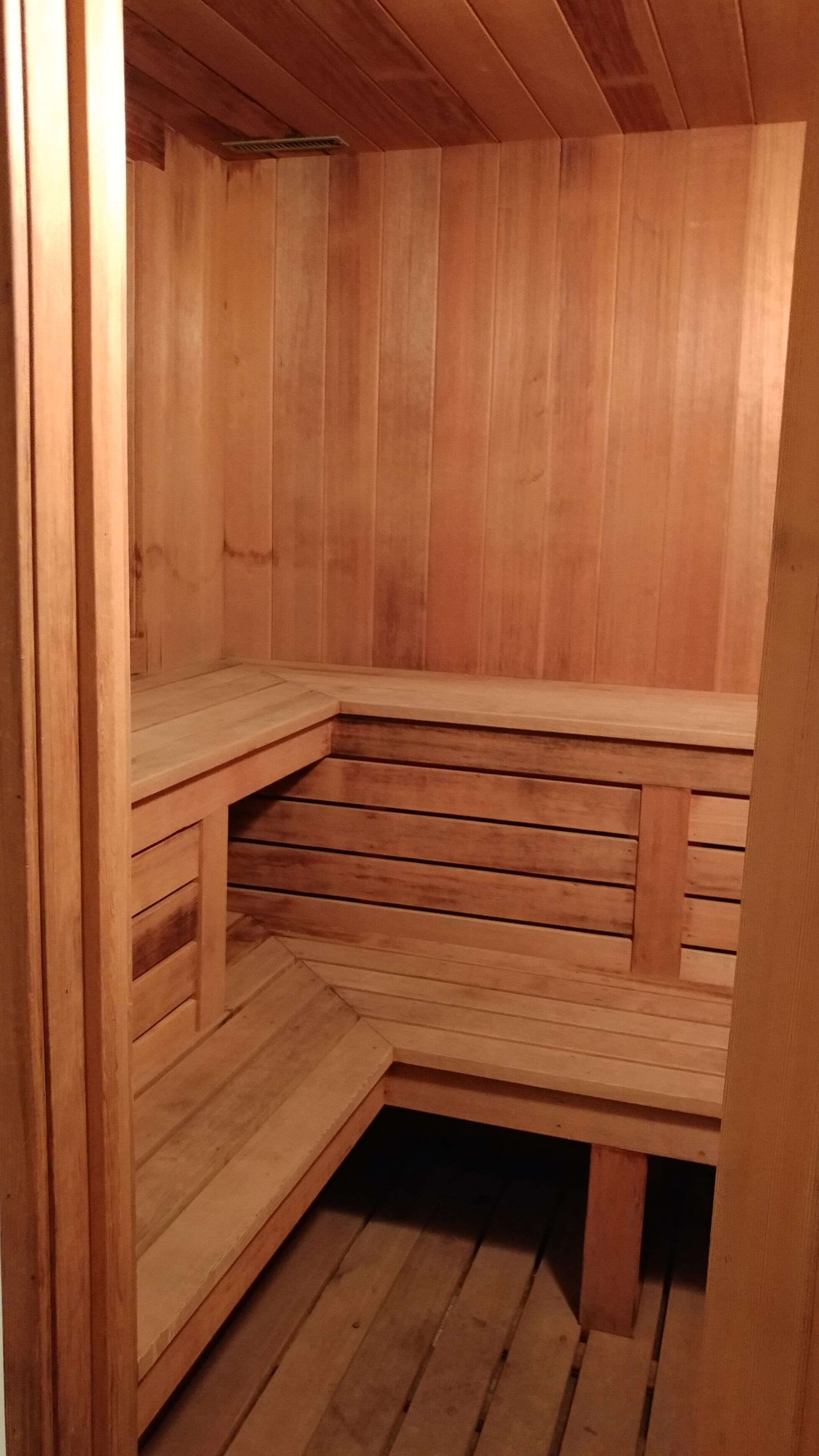 A wooden sauna with a bench and steps.