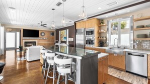 Una cucina moderna con isola centrale, elettrodomestici in acciaio inossidabile e un angolo bar con sgabelli.