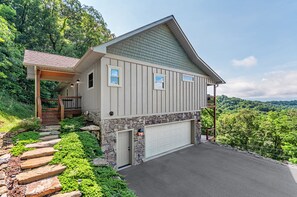 Surrounded by lush greenery, this two-story house offers a scenic view of the surrounding landscape.