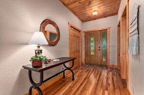 Stunning hallway with a door, table, and plants, set against a backdrop of exposed beams.