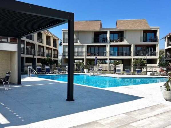 Ein Hotel mit Schwimmbad, Außenbereich und überdachter Terrasse.