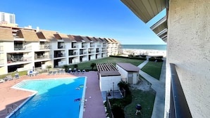 Un hotel con piscina, diversi balconi e vista sulla spiaggia.
