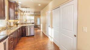 A spacious kitchen with wooden cabinets, a stainless steel dishwasher, and a granite countertop. - Townhome 5 in Springdale, at Zion National Park (Springdale)