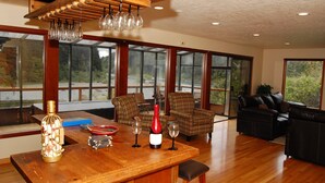 A spacious living area with large windows, a wooden bar, and leather furniture.